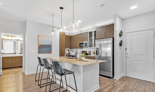 a kitchen with a bar and chairs